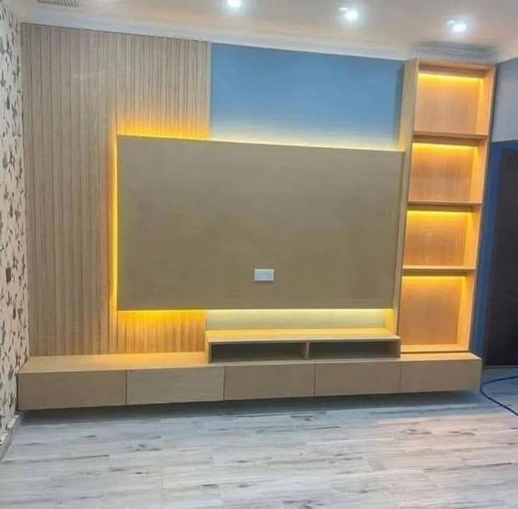 TV feature wall with built-in cabinetry and concealed lighting in a Doha living room (view 4)
